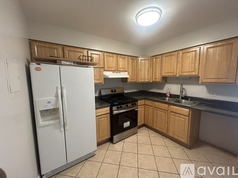 A kitchen with wooden cabinets and a white fridge.