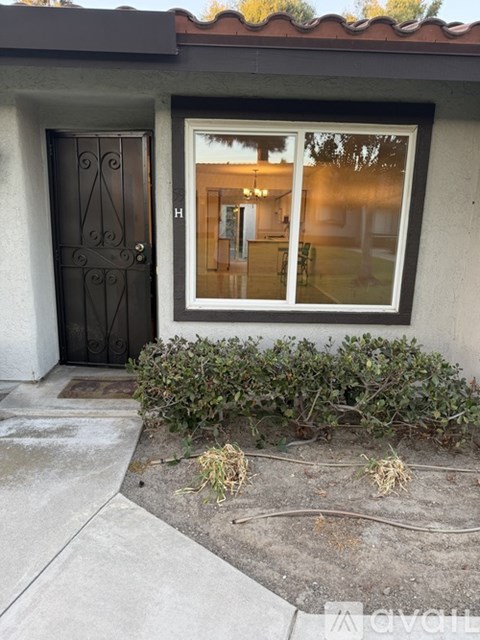 A house with a black door and a window showing the interior.