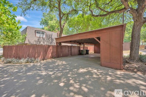 A modern house with a red garage door is surrounded by trees.