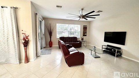 A living room with a red couch and a television.