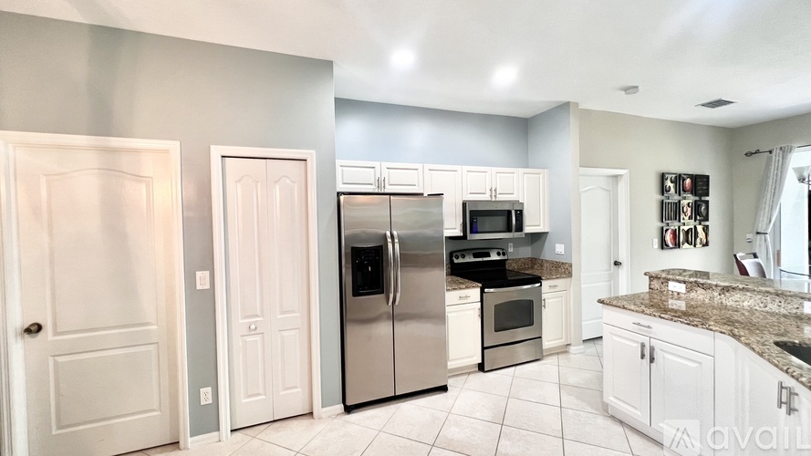 A kitchen with white cabinets and appliances.