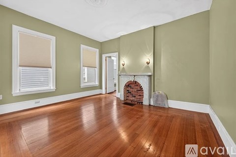 A room with wooden floors and a fireplace.