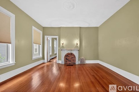 A room with a fireplace and wood flooring.