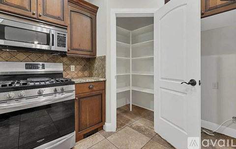 A kitchen with a black stove top oven and a white refrigerator.