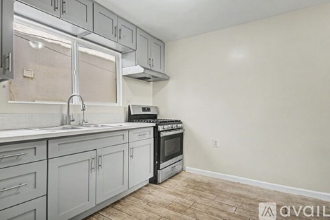 A kitchen with a stove top oven and a sink.