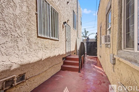 A narrow alley with a red floor and buildings on either side.