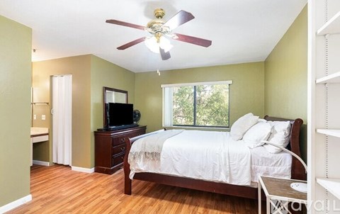 A bedroom with a bed, dresser, and television.