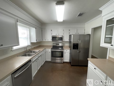 A kitchen with white cabinets and stainless steel appliances.