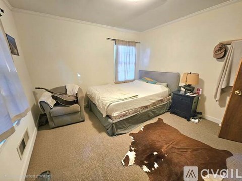 A bedroom with a bed, nightstand, and chair.