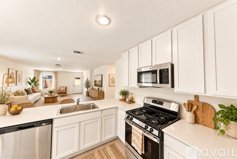 A kitchen with white cabinets and a black stove top oven.