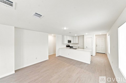 A spacious living room with a white sofa and wooden flooring.