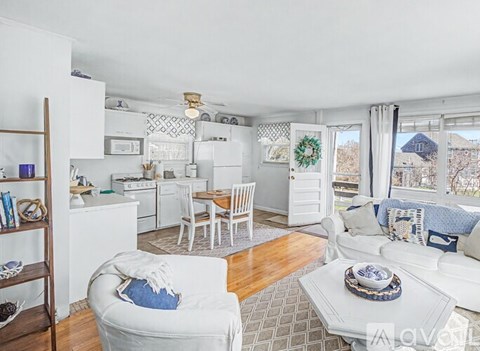 A living room with a white couch and a wooden floor.