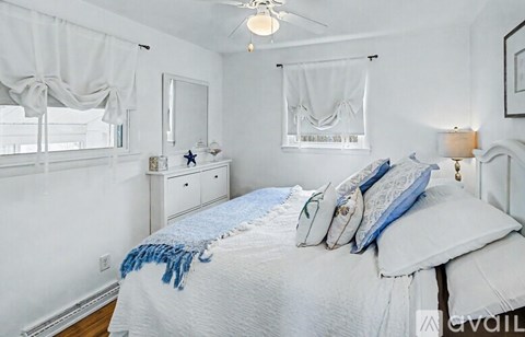 A bedroom with a bed, nightstand, and window.