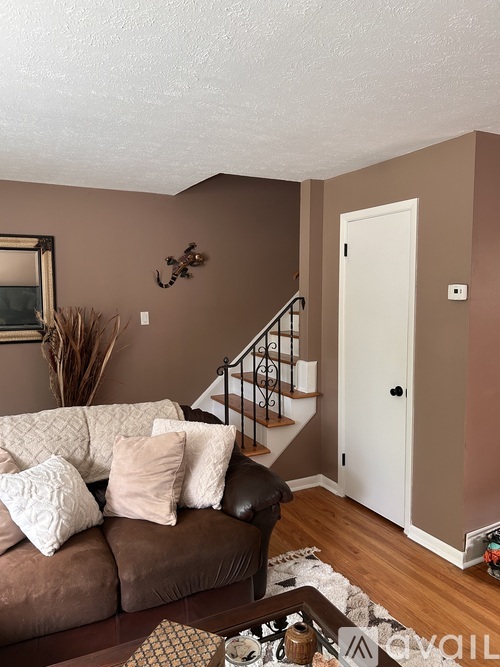 A living room with a brown couch and a white door.