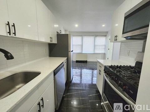 A kitchen with black and white appliances and cabinets.