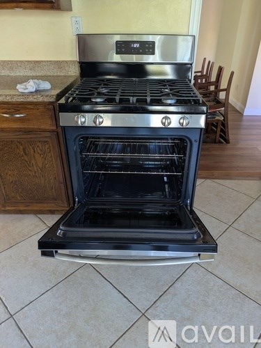A modern stove with a digital display is in a kitchen.