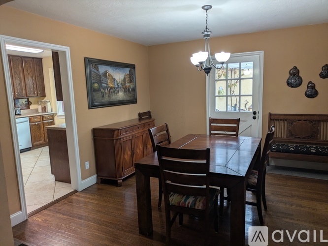 A dining room with a wooden table and chairs.