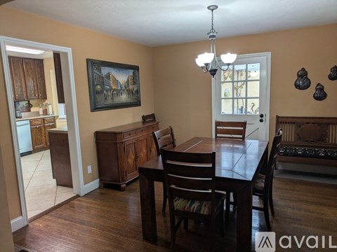 A dining room with a wooden table and chairs.