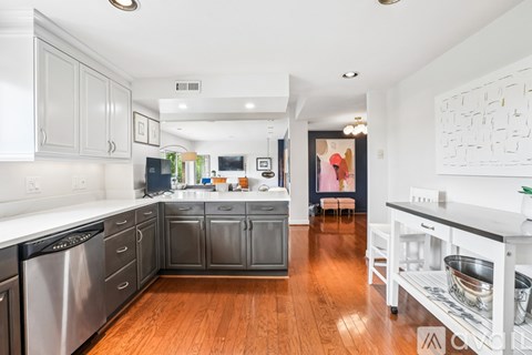A kitchen with wooden floors and a white counter top.