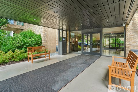 A wooden bench sits in front of a glass door with a sign that reads "2200".