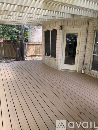 A wooden deck with a white door and a white awning.