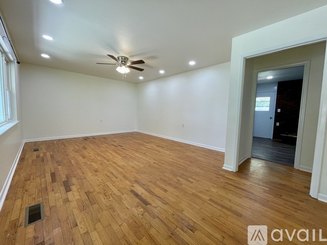 A room with wooden flooring and a ceiling fan.