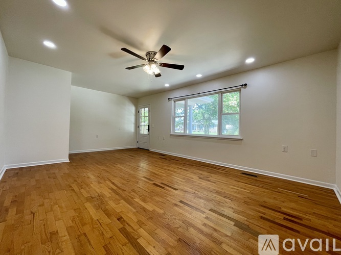A room with wooden flooring and a ceiling fan.