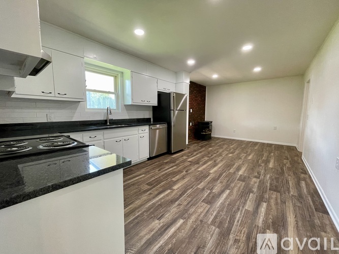 A kitchen with a black countertop and white cabinets.