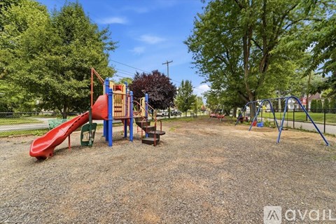 A playground with a red slide and a blue and yellow structure.