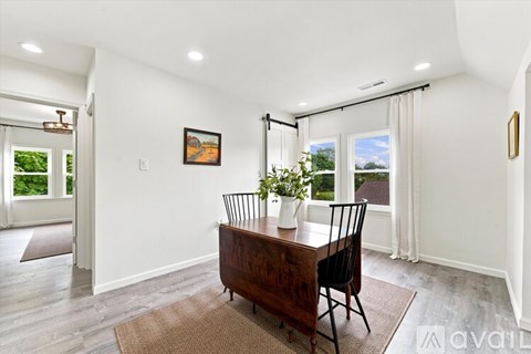A dining room with a wooden table and chairs.