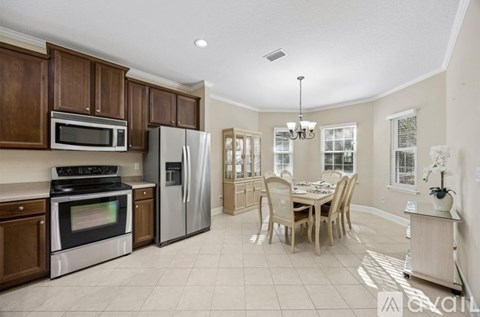 A kitchen with a refrigerator, oven, and microwave.