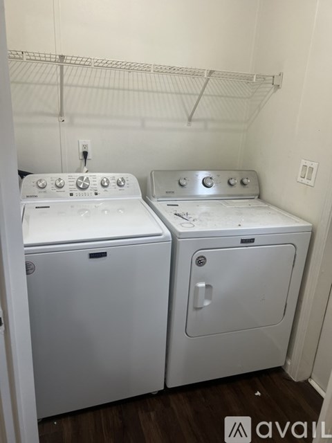 Two white front loading washing machines in a small laundry room.