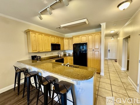 A kitchen with wooden cabinets and a granite countertop.