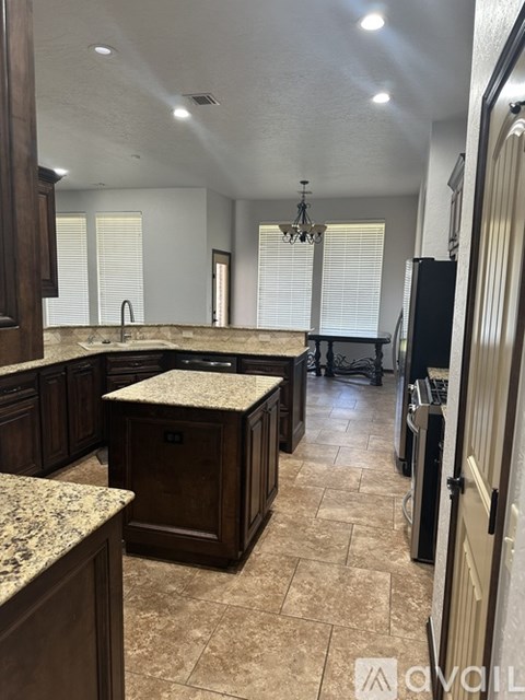 A kitchen with brown cabinets and granite countertops.