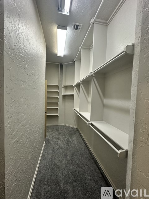 A long hallway with a carpeted floor and white walls.