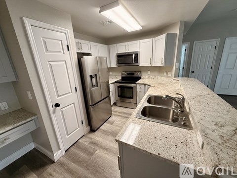 A kitchen with a granite countertop and stainless steel appliances.