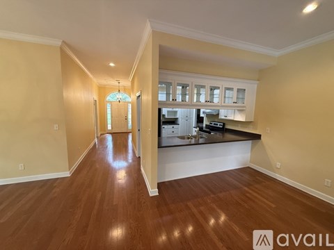 A kitchen with wooden floors and a dining area with a table and chairs.
