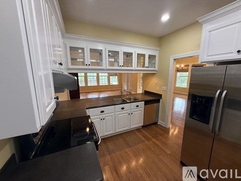 A kitchen with white cabinets and a black stove top oven.