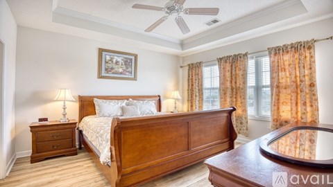A bedroom with a bed, nightstand, and a ceiling fan.