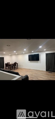 A living room with a couch, chairs, and a television.
