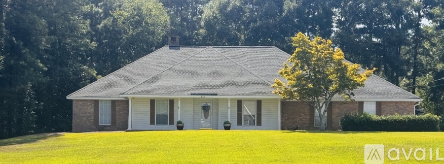 A house with a tree in front of it is for sale.
