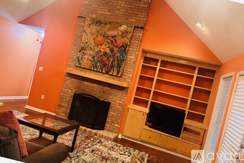A living room with a fireplace and a painting above it.