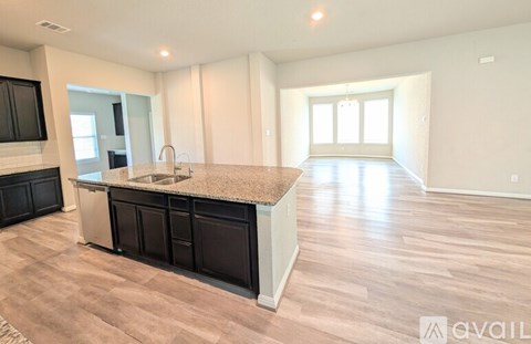 A kitchen with a granite countertop and wooden flooring.