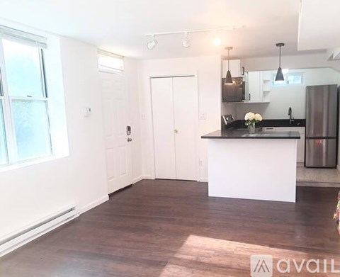 A kitchen with a white island and a refrigerator.