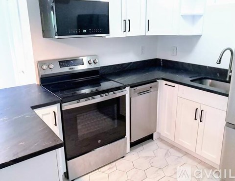 A kitchen with black countertops and white cabinets.