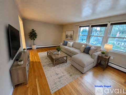 A living room with a couch, a coffee table, and a television.