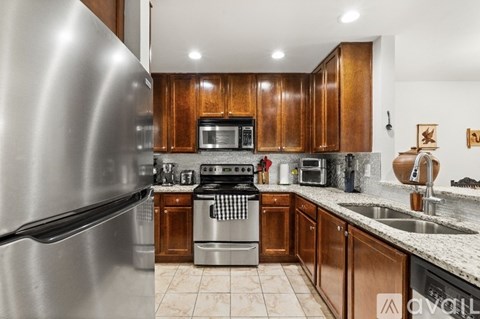 A modern kitchen with wooden cabinets and stainless steel appliances.