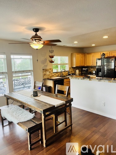 A kitchen with a table and chairs in front of a window.