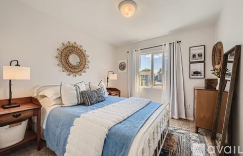 A bedroom with a large bed and a mirror on the wall.