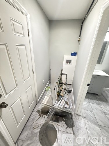 A white door is on the left and a white fridge is on the right.